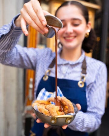 waitress pouring sweet syrup over dessert