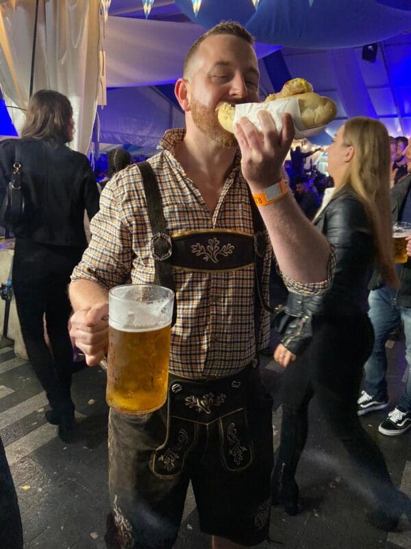 german man eating hot dog and drinking beer