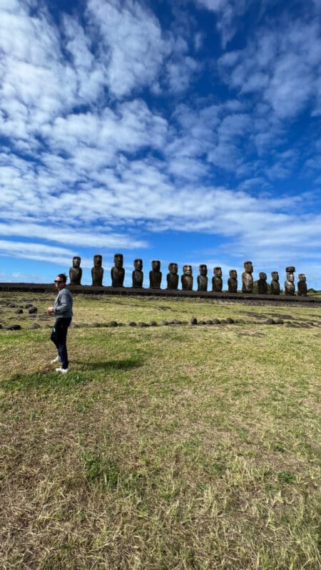 man with rapa nui statues at archaeological site in easter island