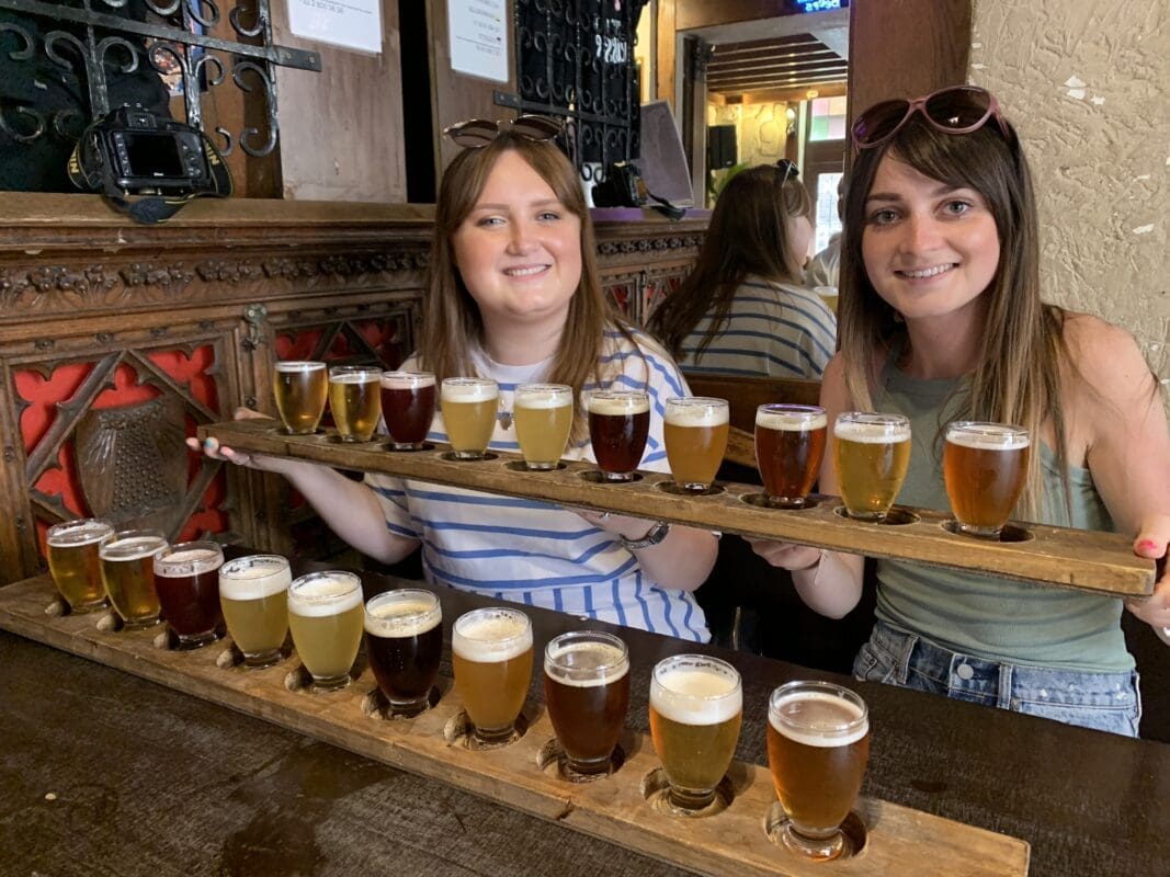 woman at a bar with two sets of ten beers