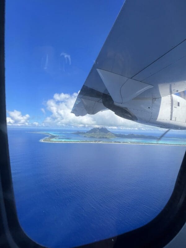 plane window with a beautiful island and the sea