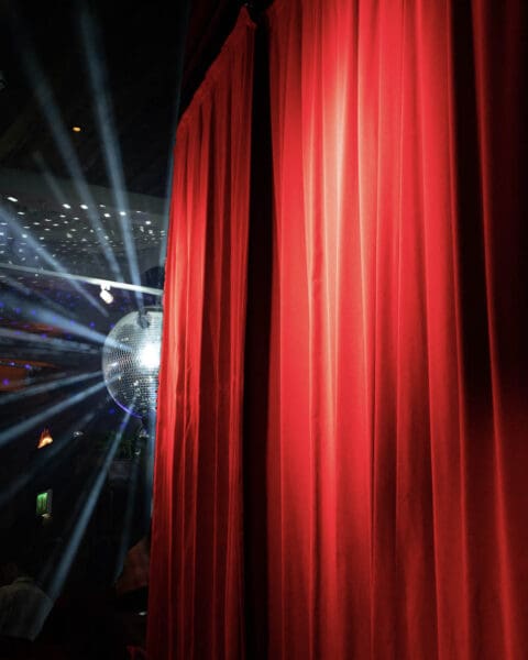 red theatre curtains and disco ball
