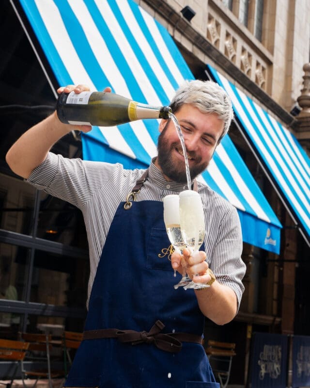 man pouring champagne into glasses